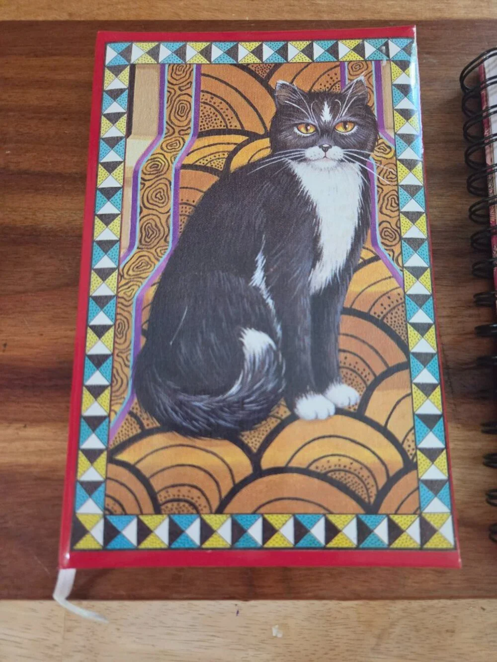 notebooks one with a cat motif and other with Indian pichwai art both have paper